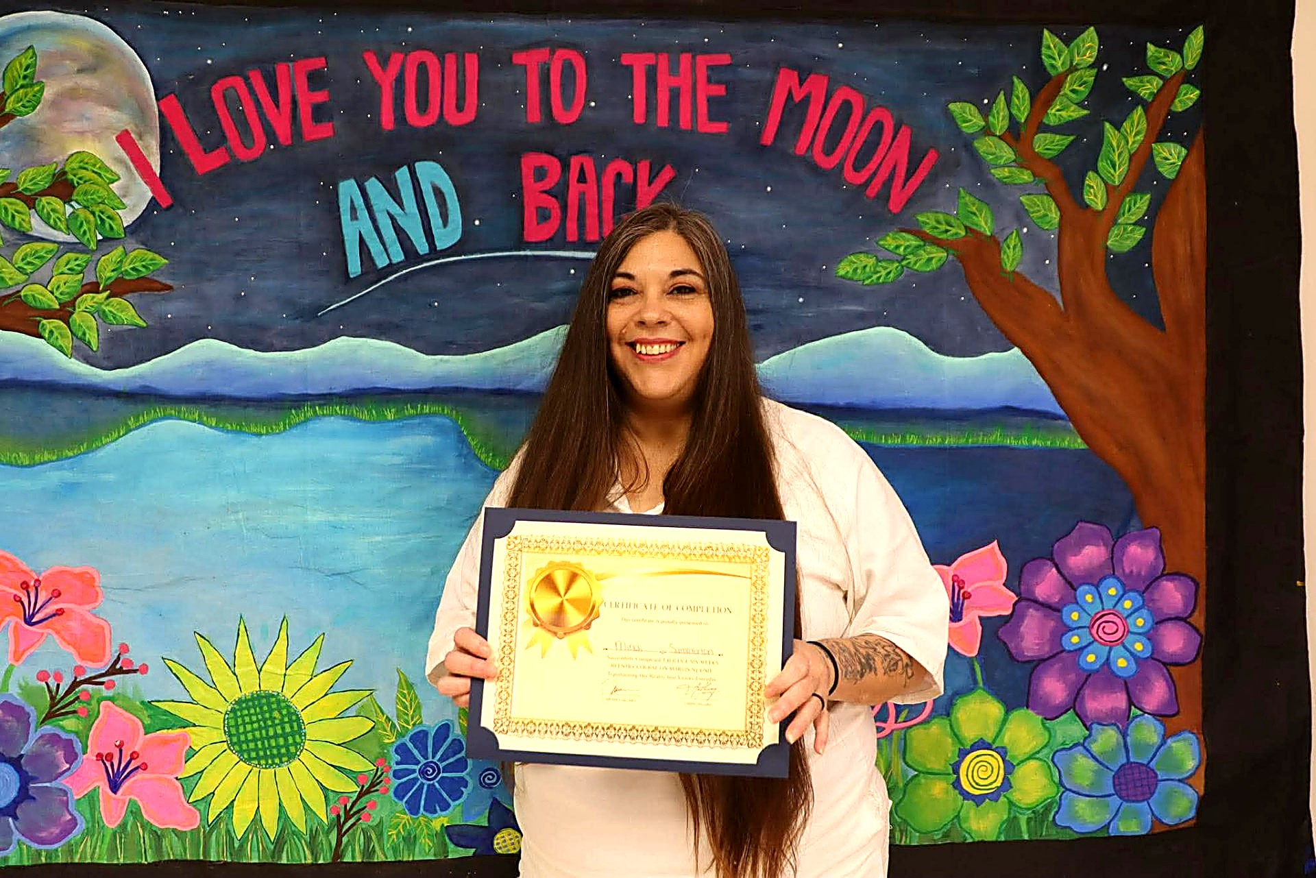 T.H.R.I.V.E. graduate holding her certificate of completion